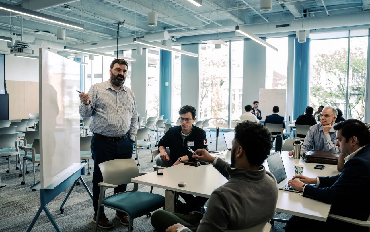 Dylan Hayden facilitating a discussion with participants around a table